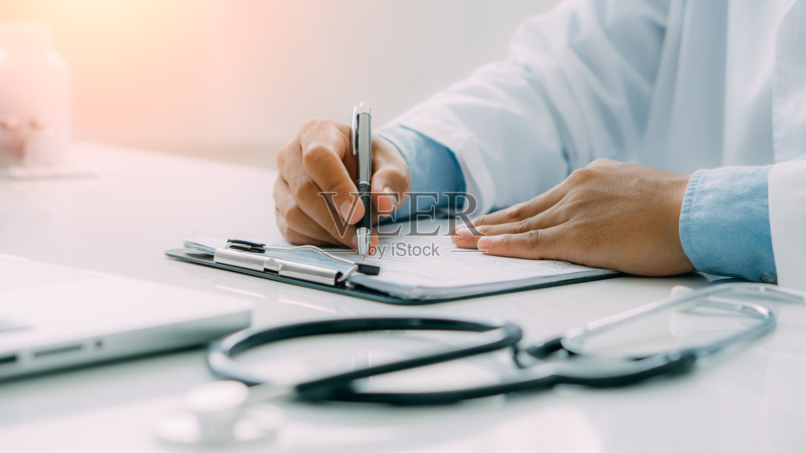 医生写处方有选择性的重点。医生用听诊器给病人开治疗处方。照片摄影图片