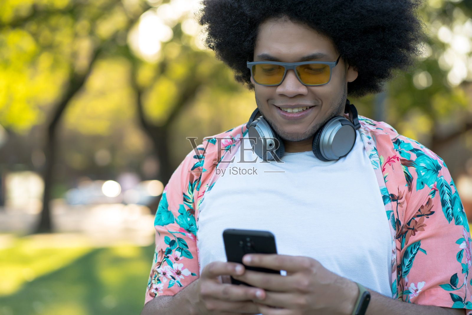 一个年轻人在户外用手机。照片摄影图片