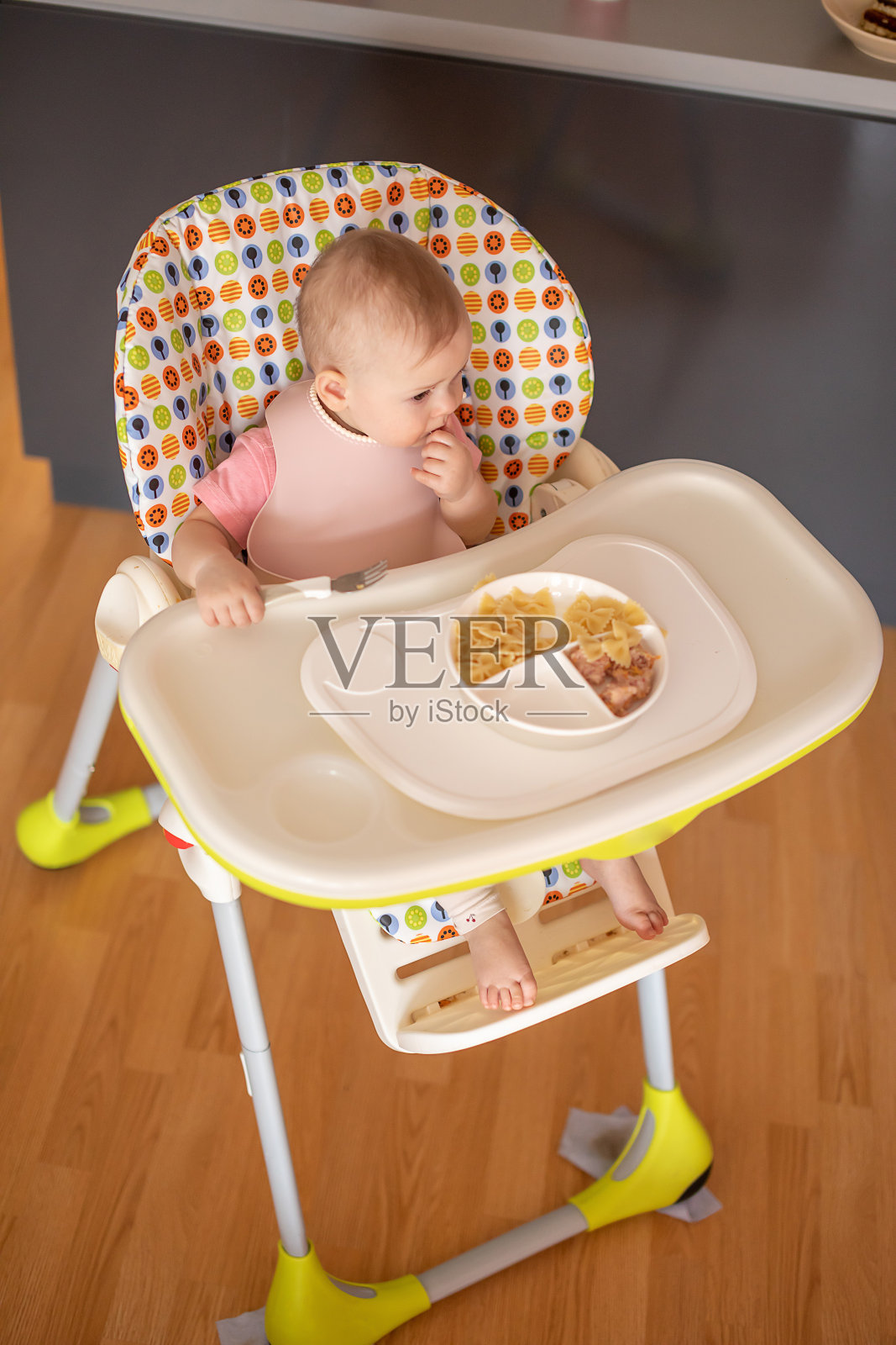 一岁女孩在婴儿餐椅上均衡饮食，为孩子提供健康均衡的营养照片摄影图片