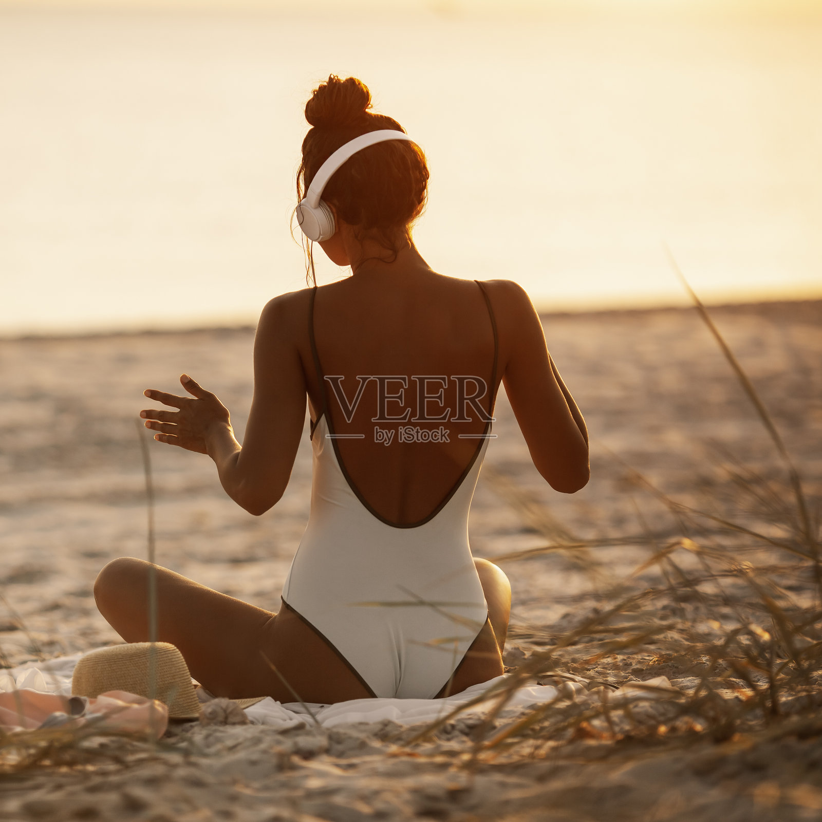 穿着比基尼的女人戴着耳机在大自然中享受音乐照片摄影图片