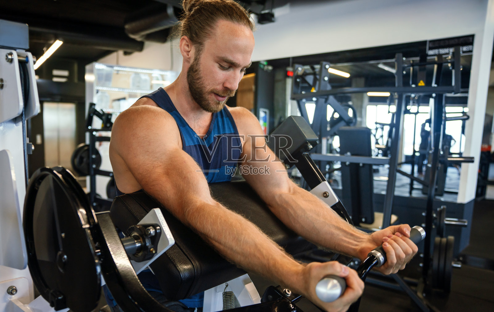 自信的年轻人在健身中心锻炼。照片摄影图片