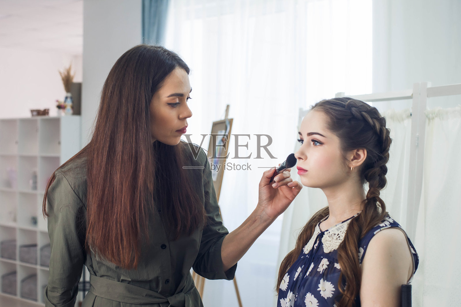 师父在美容院给金发美女化妆照片摄影图片