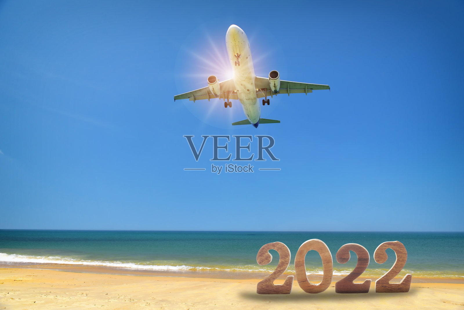 2022年新年和商用飞机在热带海滩和蓝天的背景下照片摄影图片