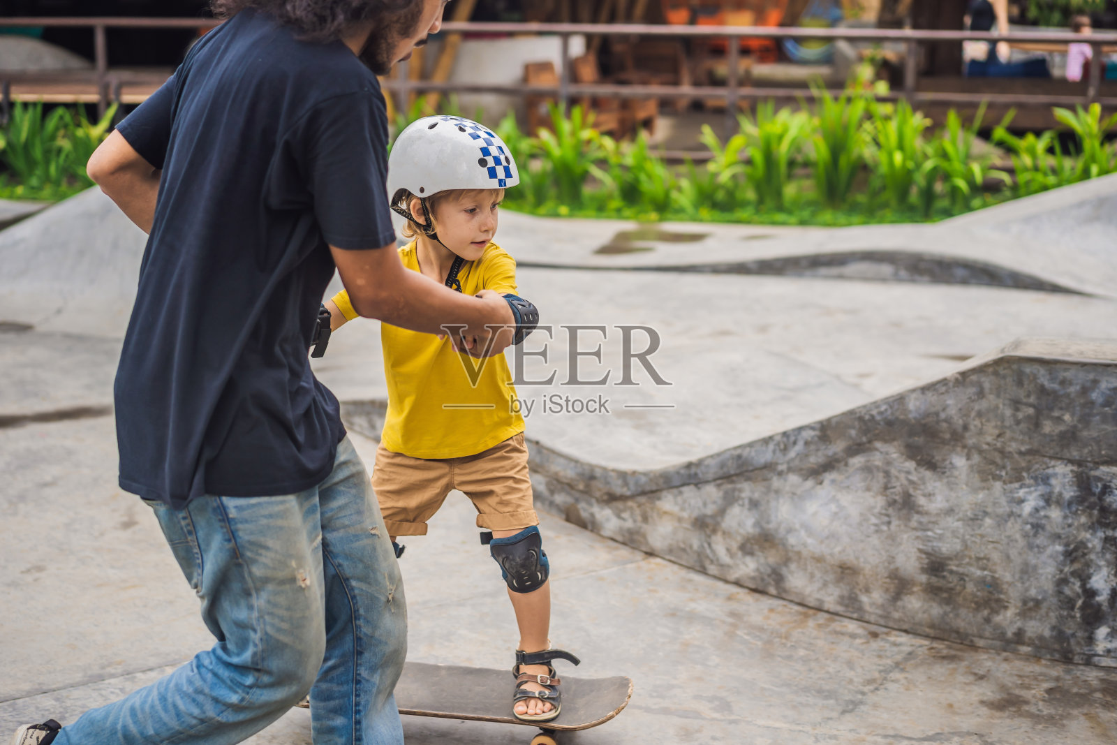 运动健将在一个滑板公园跟教练学滑板。儿童教育、体育照片摄影图片