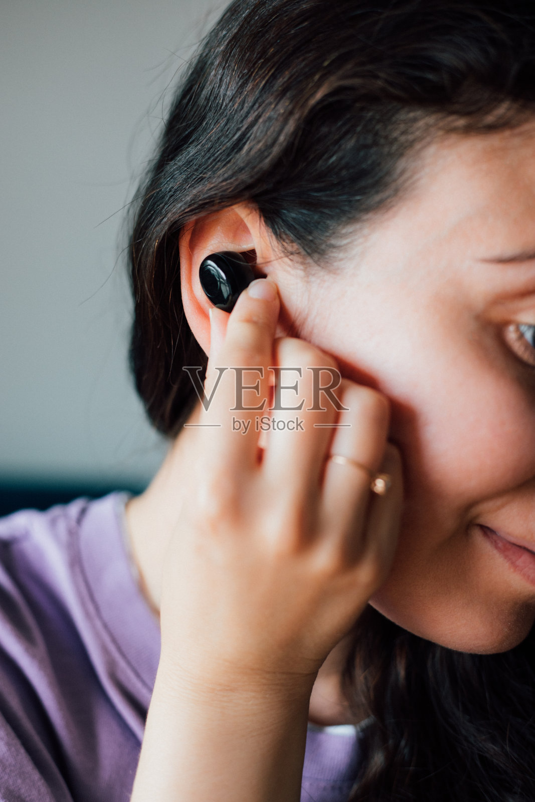 女人戴着无线耳机，拿着智能手机照片摄影图片