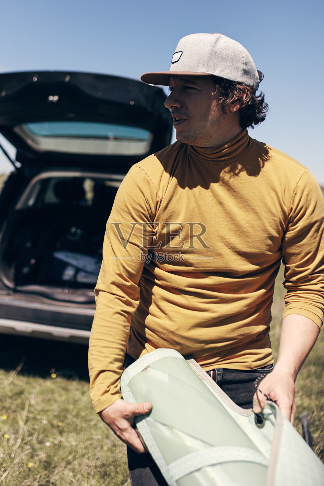 风帆和露营者从汽车的车顶行李架打包和拆包。照片摄影图片