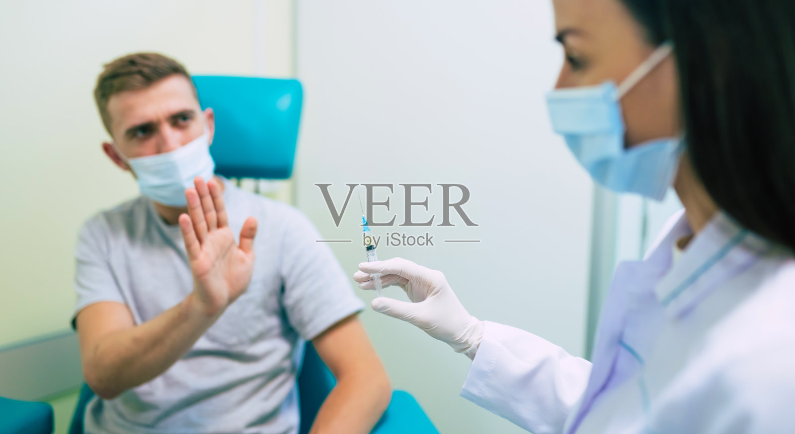 没有疫苗。一名害怕的男子示意停止递上注射疫苗的注射器，拒绝接种疫苗。针恐，害怕Covid-19疫苗照片摄影图片