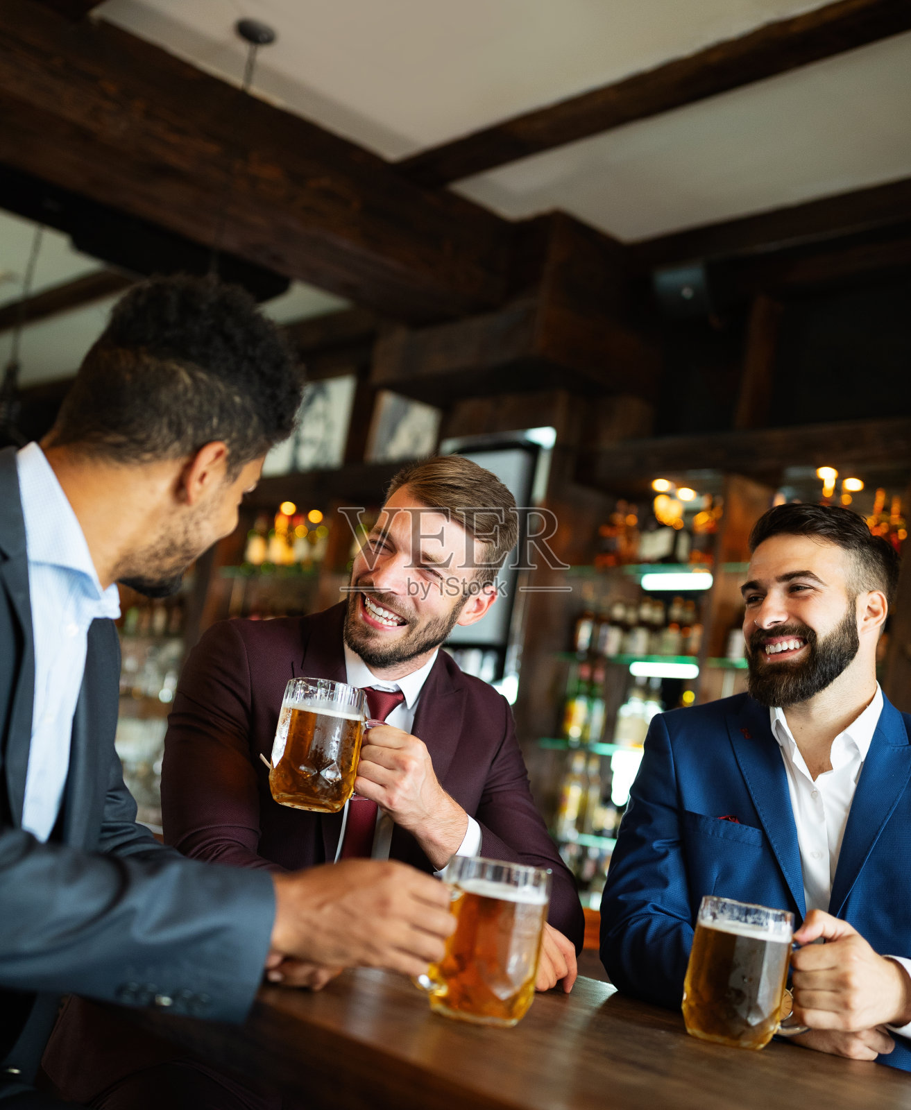 人、友谊、庆典理念。快乐的商业男性朋友在酒吧喝啤酒照片摄影图片
