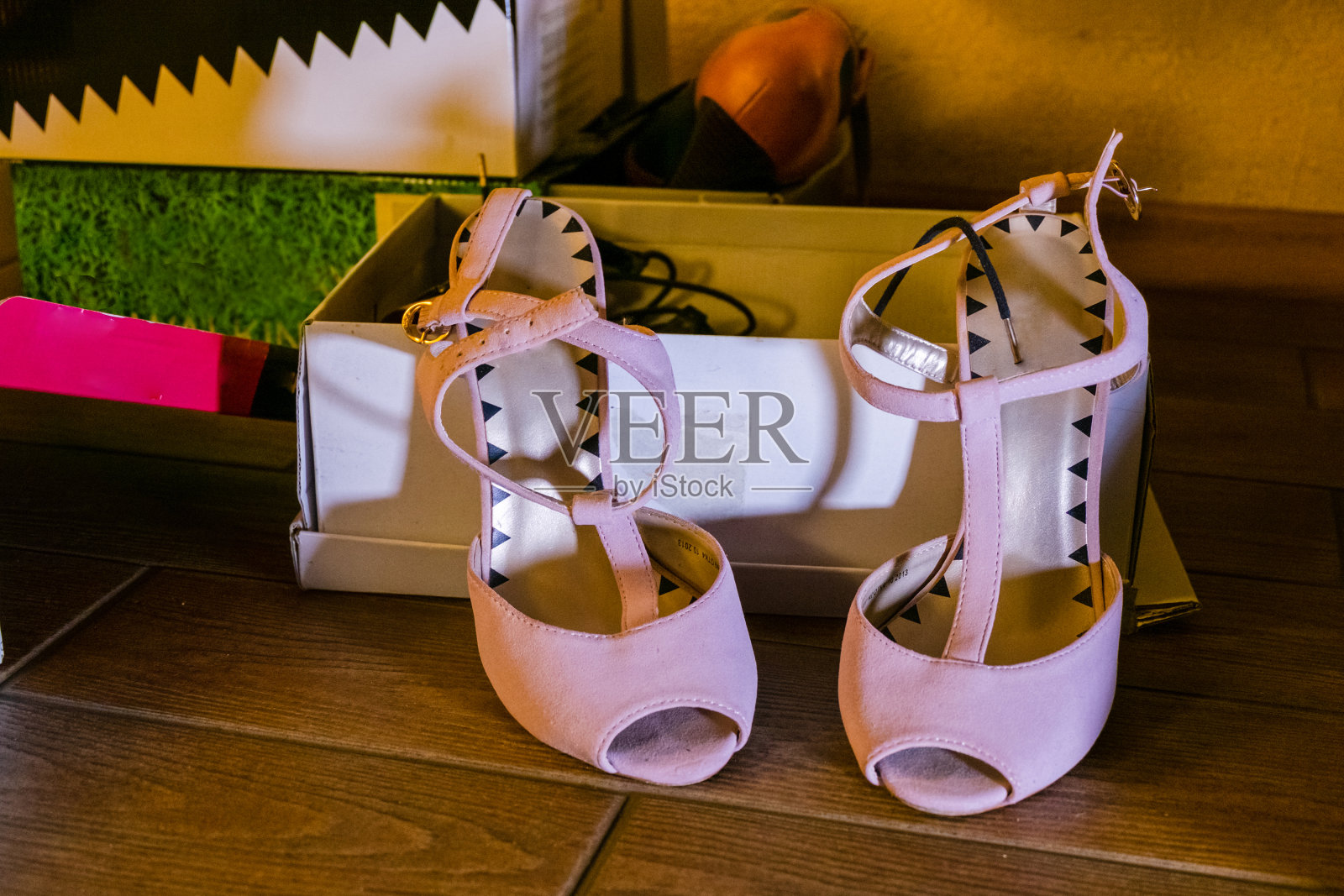 在开着的鞋盒背景上的旧粉色高跟鞋。照片摄影图片