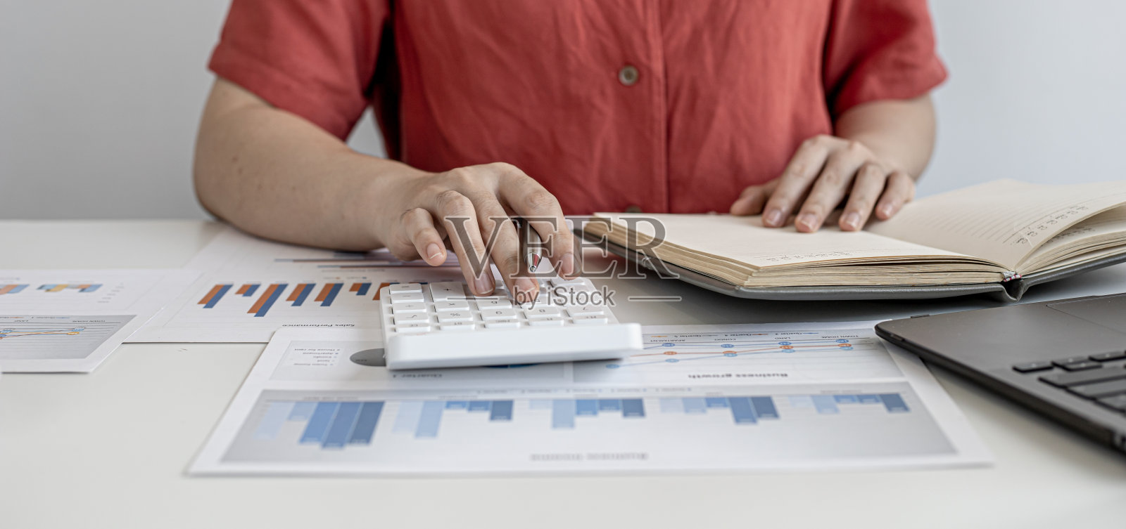 公司的财务人员正在按计算器核对准备好的财务文件上的数字，准备带去与管理层的会议。公司财务的概念。照片摄影图片