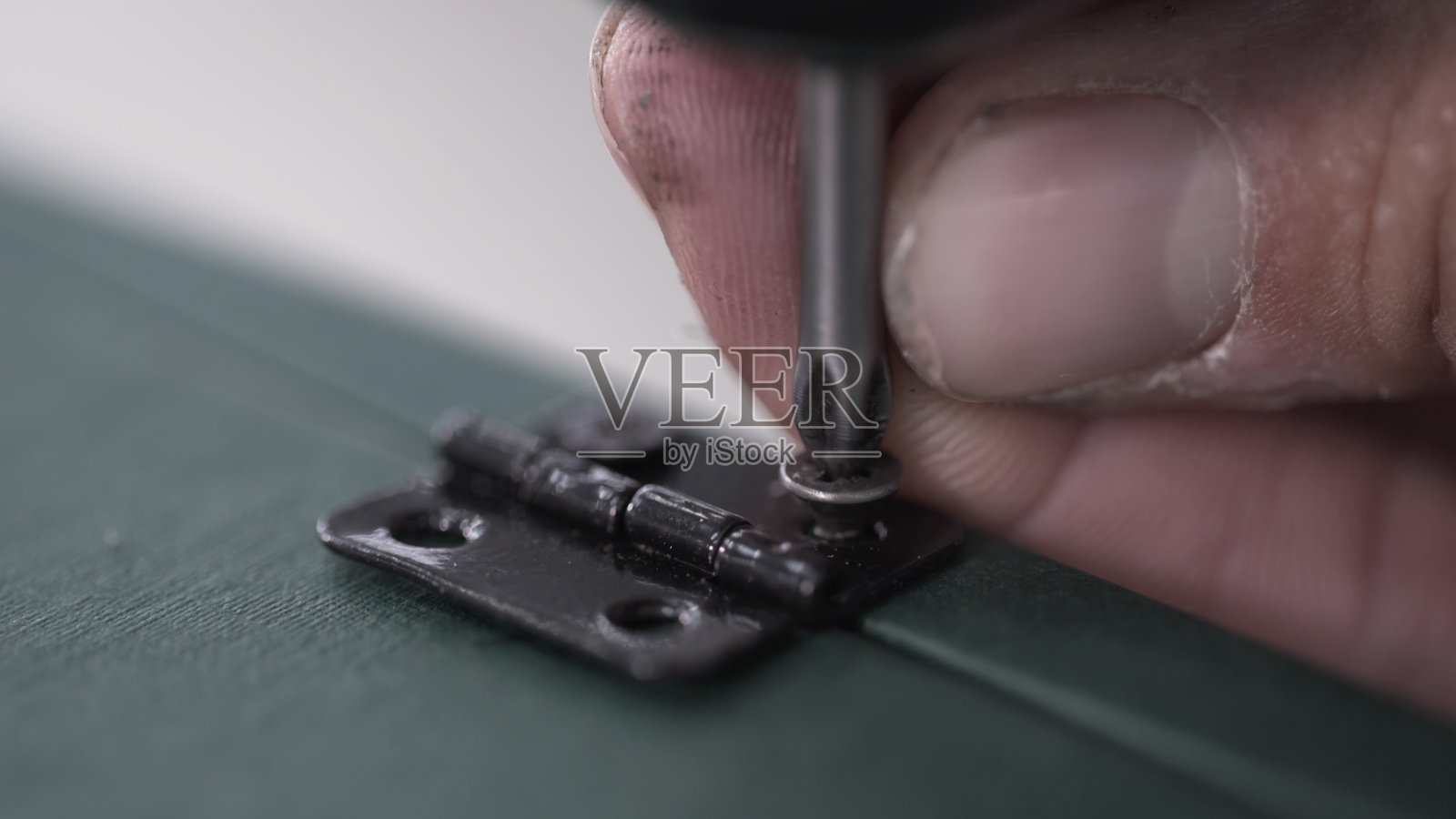 关闭工具螺丝刀旋转螺丝。用电钻插入凸轮锁紧螺钉照片摄影图片