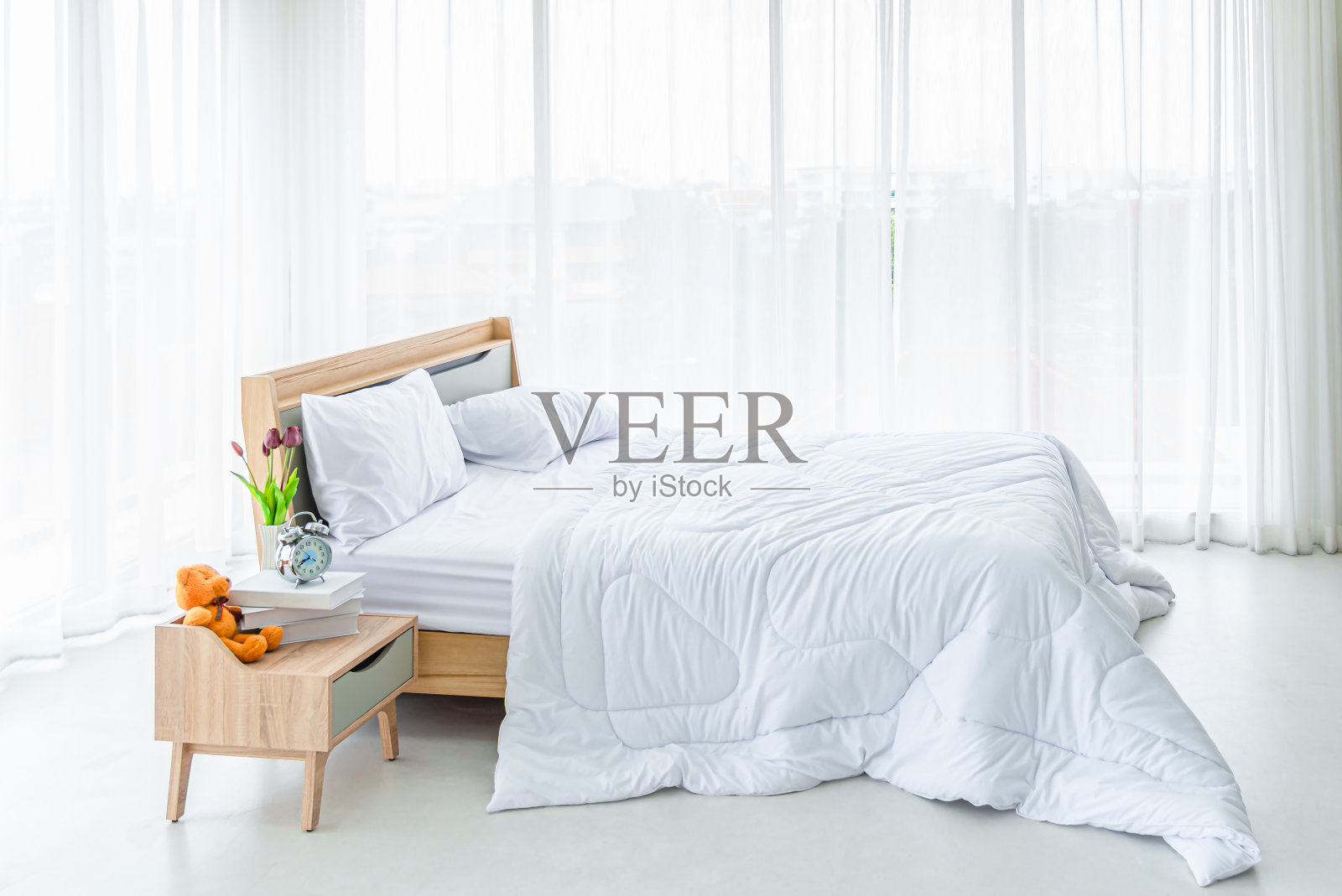 室内白色的卧室，白色的窗帘和白色的枕头在木床上照片摄影图片