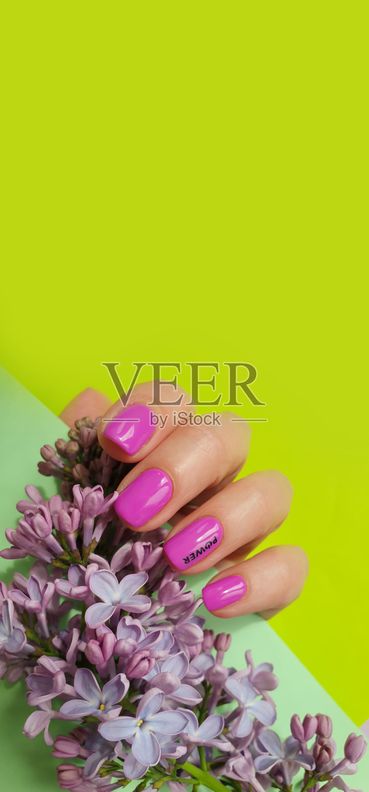 女性手美丽的美甲在一个彩色的背景花紫丁香照片摄影图片