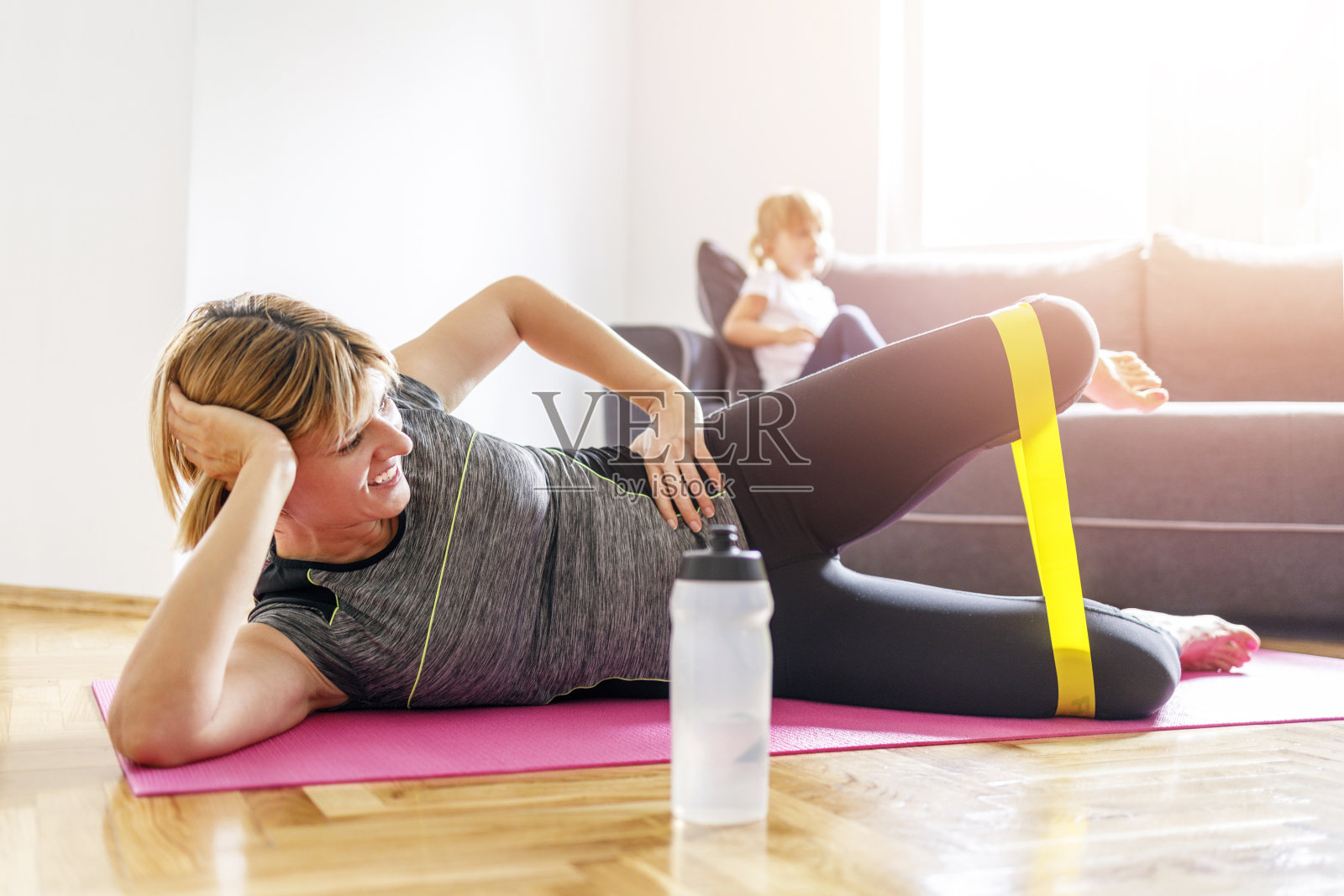 女人在家里做腿部运动时微笑照片摄影图片