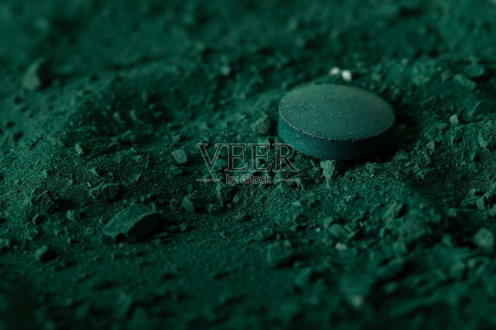 绿色螺旋藻片和藻粉营养补充宏近俯视。照片摄影图片