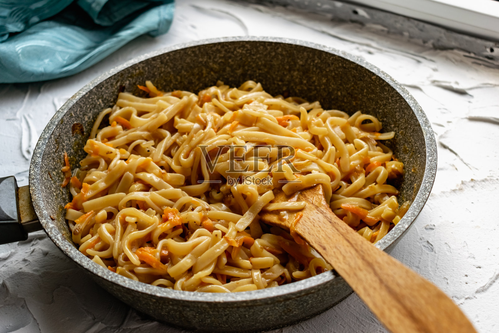 丰盛的意大利面与油炸蔬菜，洋葱和胡萝卜在煎锅里。为全家准备的美味家常菜照片摄影图片
