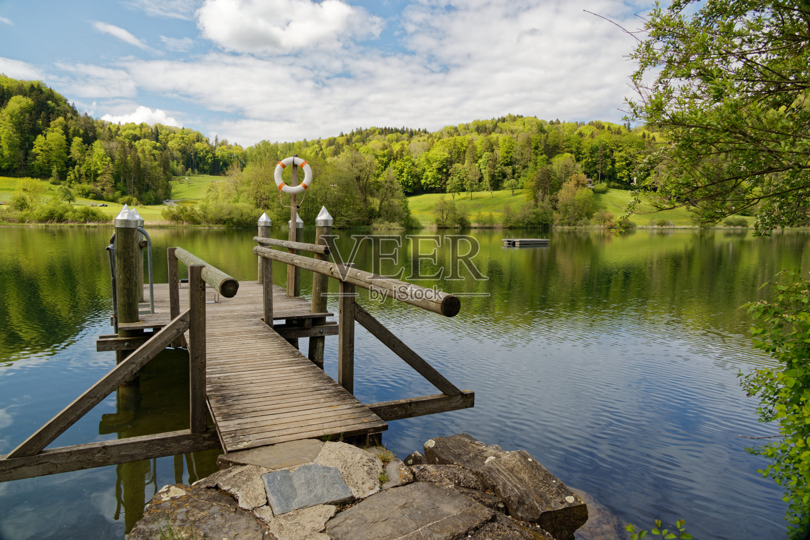 湖室外泳池设有游泳平台、游泳生活圈，在绿色景观中设有美丽的棕色木墩供游泳者使用，室外泳池因日冕危机而关闭，白天无人居住照片摄影图片