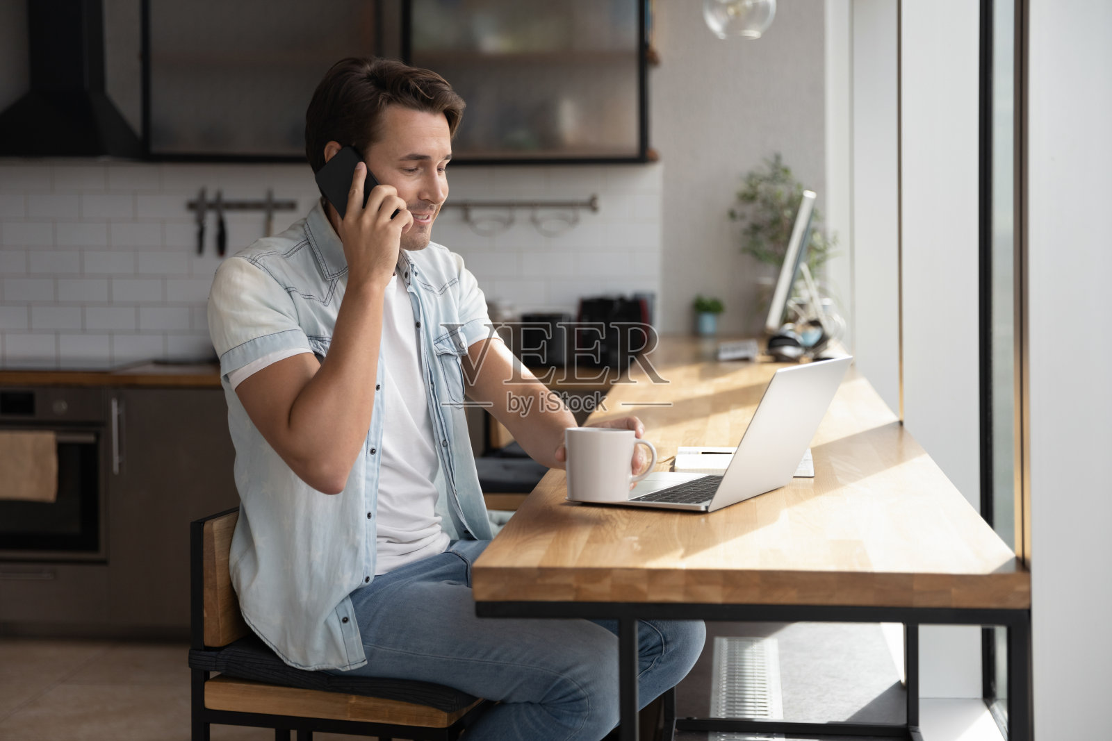 年轻人使用笔记本电脑并打电话照片摄影图片