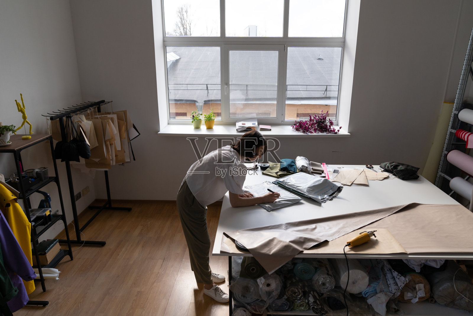 在车间订制服装:女裁缝丝锥服装交付给客户。职场女性设计师照片摄影图片