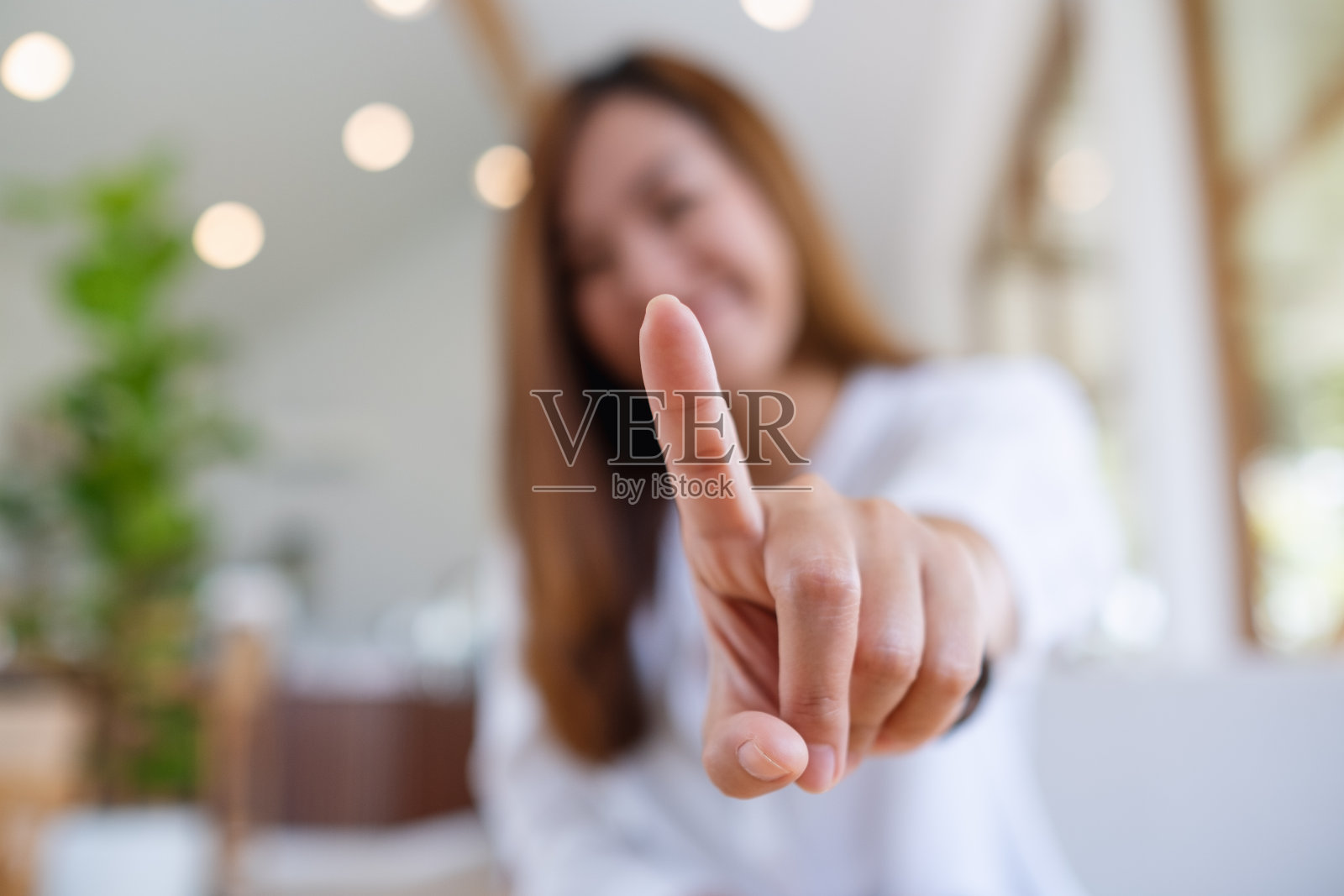 一个年轻漂亮的亚洲女人触摸或指着你照片摄影图片