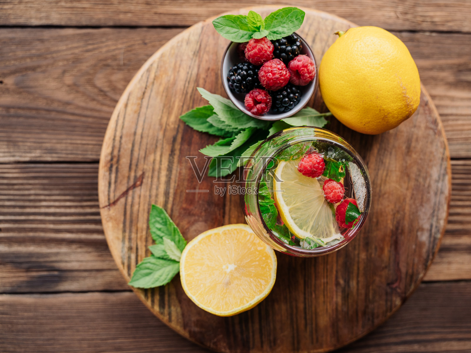 健康排毒饮料由柠檬、薄荷和浆果在一个木制的背景。柠檬水的成分。水果茶。饮食的概念。俯视图照片摄影图片