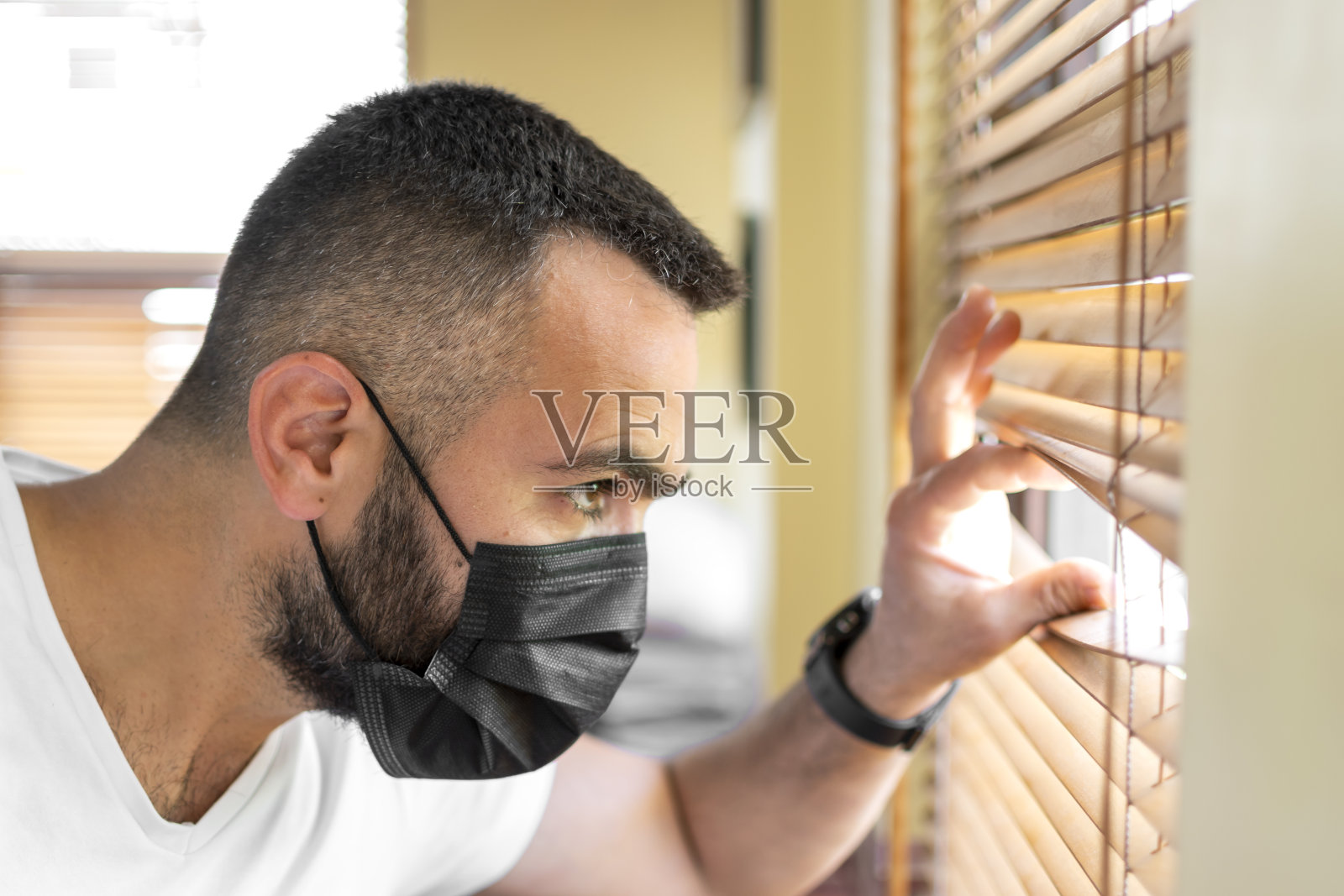 英俊的看着从窗口隔离口罩照片摄影图片