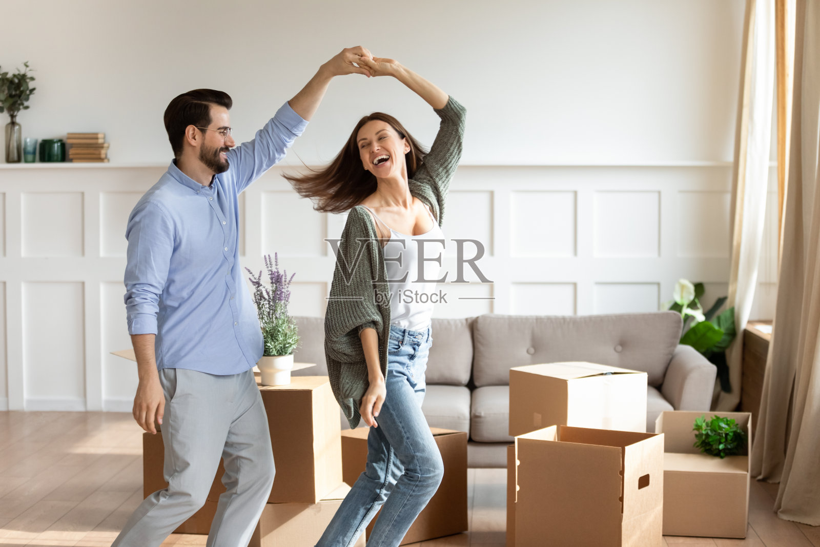 快乐的情侣跳舞庆祝搬迁到新家照片摄影图片