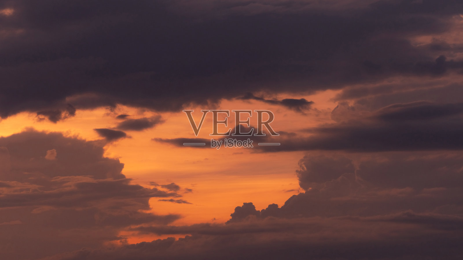 美丽的橙色日落天空与灰色和黑色的云层。风景优美的观点。自然美。黄昏的天空。黄昏天空为宁静祥和的背景。浪漫的日落的天空。照片摄影图片