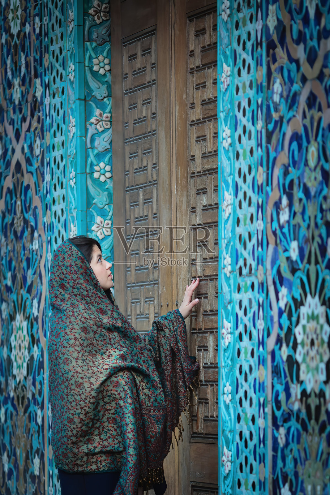 戴头巾的鞑靼族穆斯林妇女在蓝色清真寺入口附近照片摄影图片