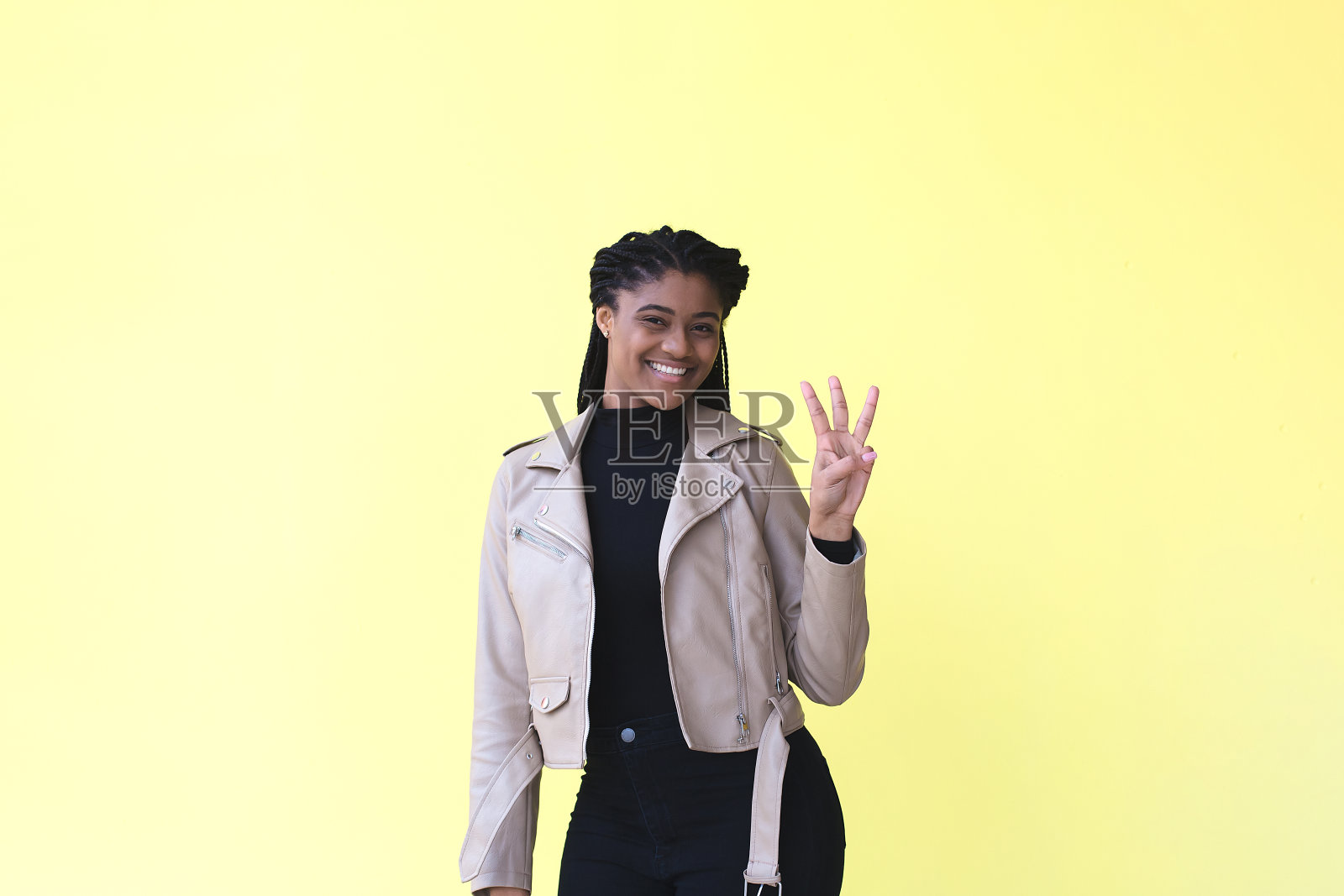 美丽而快乐的非裔美国妇女用手指数到5，在黄色的背景上照片摄影图片