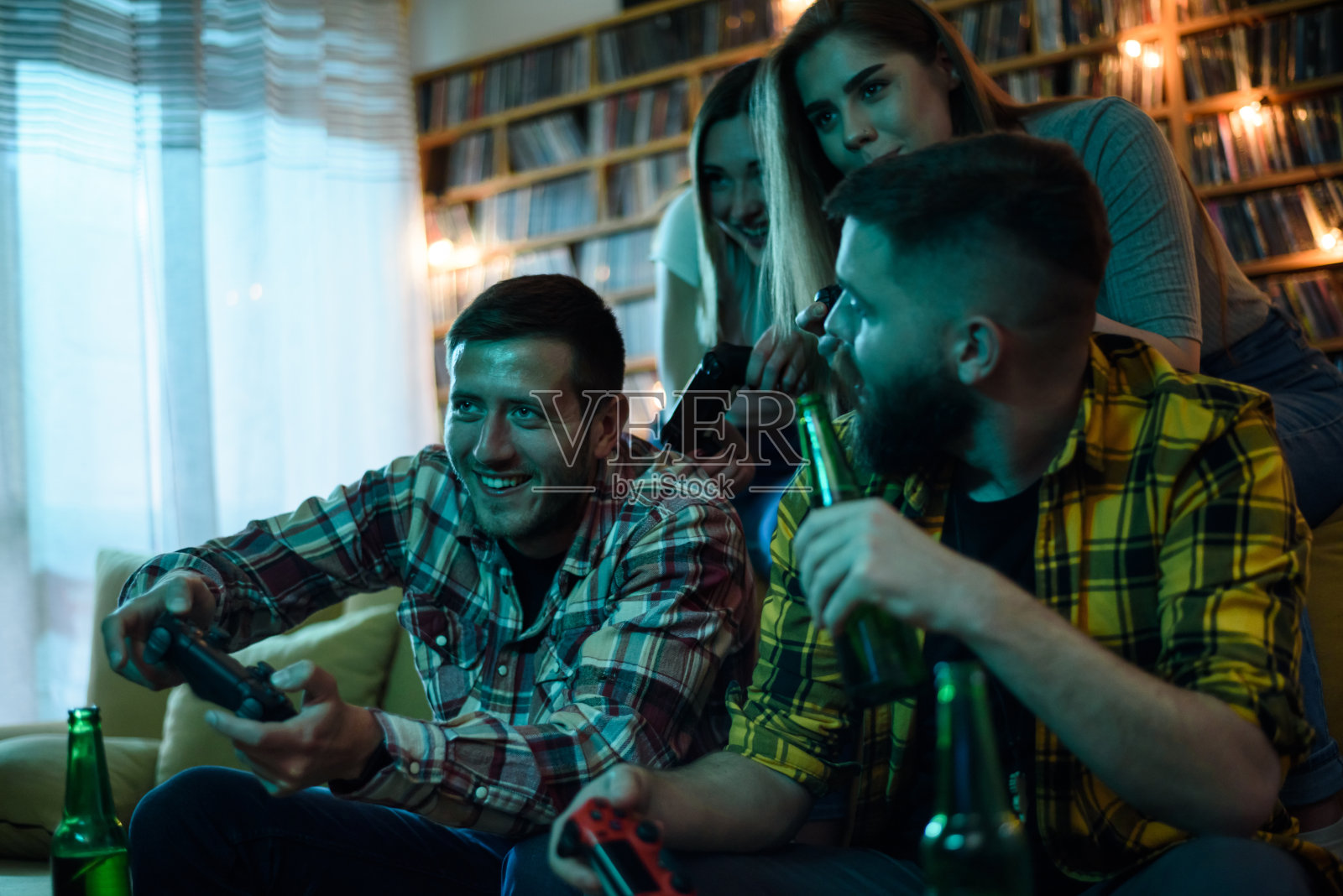 年轻有趣的一群朋友玩电子游戏和喝啤酒照片摄影图片