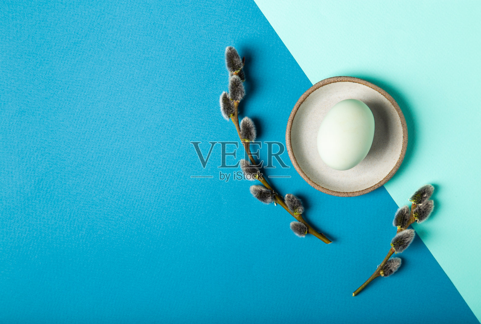 顶视图彩色鸡蛋与柳枝在双色蓝色背景照片摄影图片