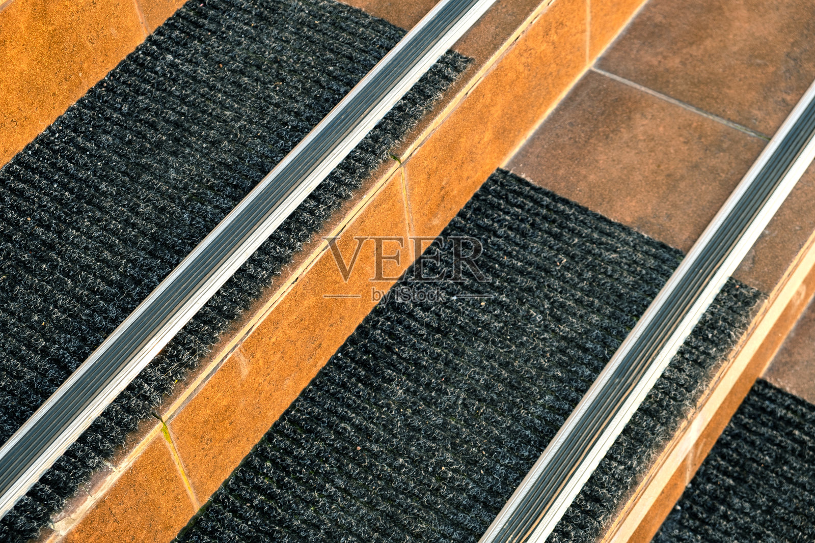 特写的瓷砖覆盖走廊楼梯与橡胶防滑条纹。照片摄影图片