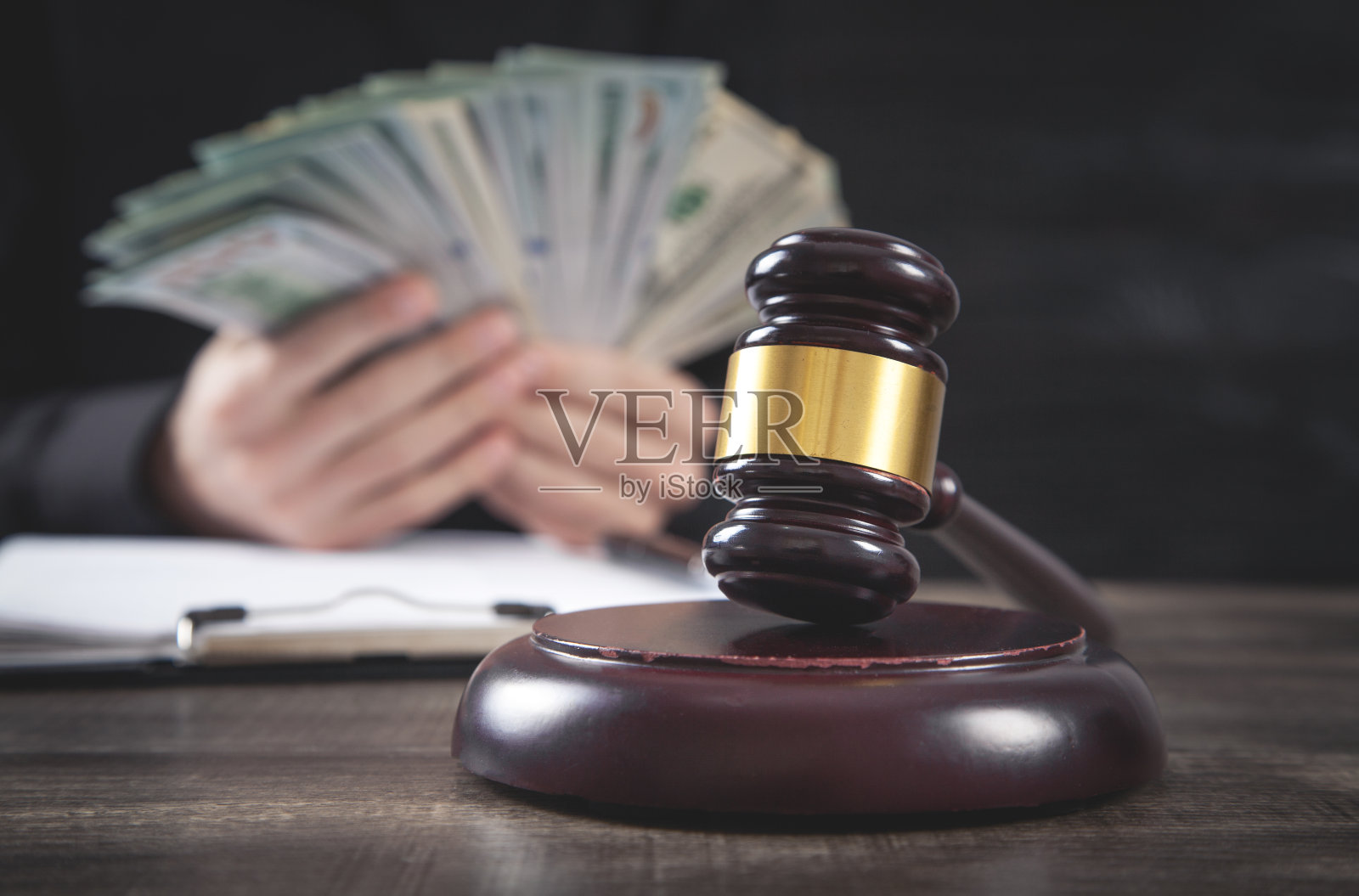 男法官拿着法官的木槌和钱。照片摄影图片