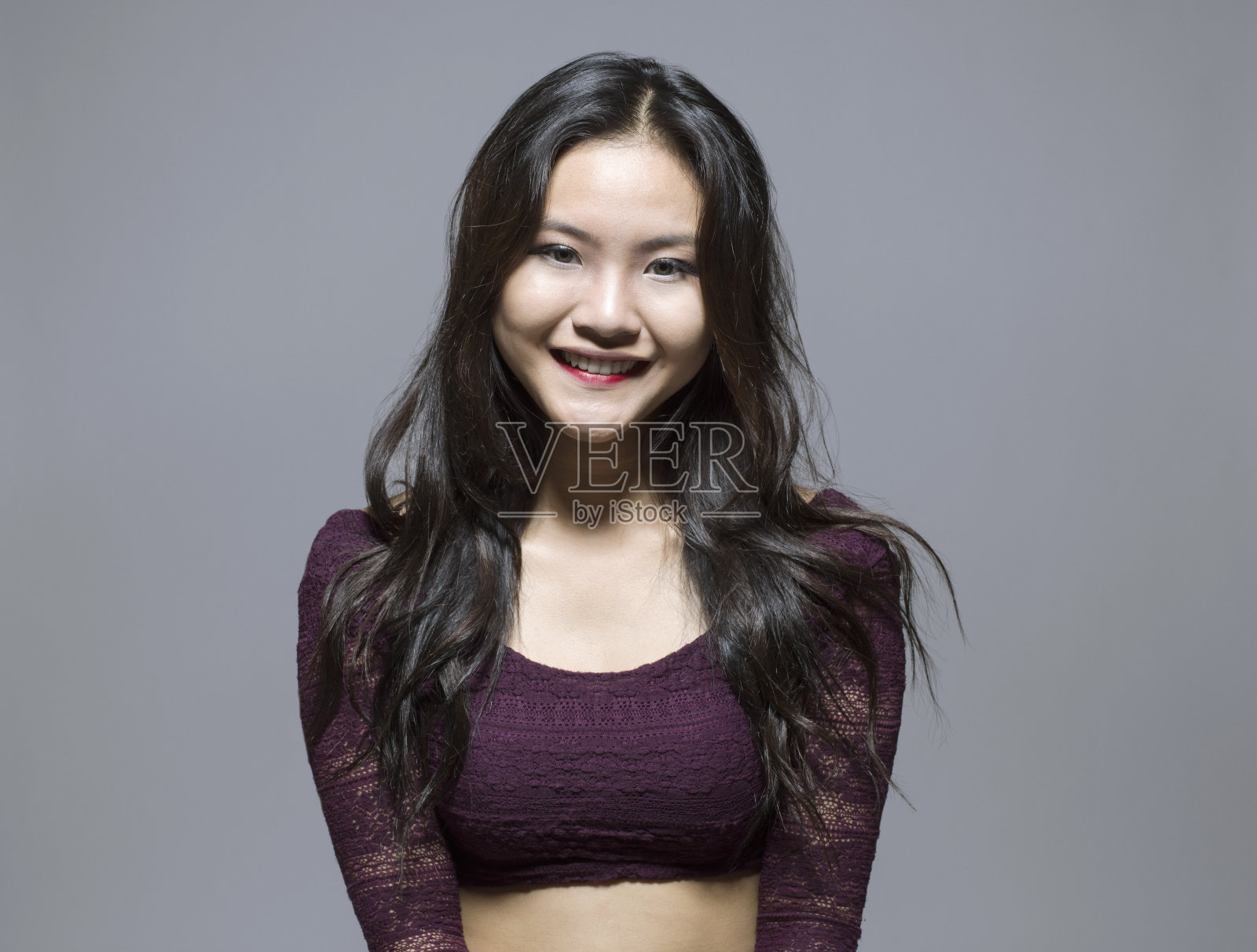 近距离微笑的年轻亚洲女子站在灰色的背景照片摄影图片