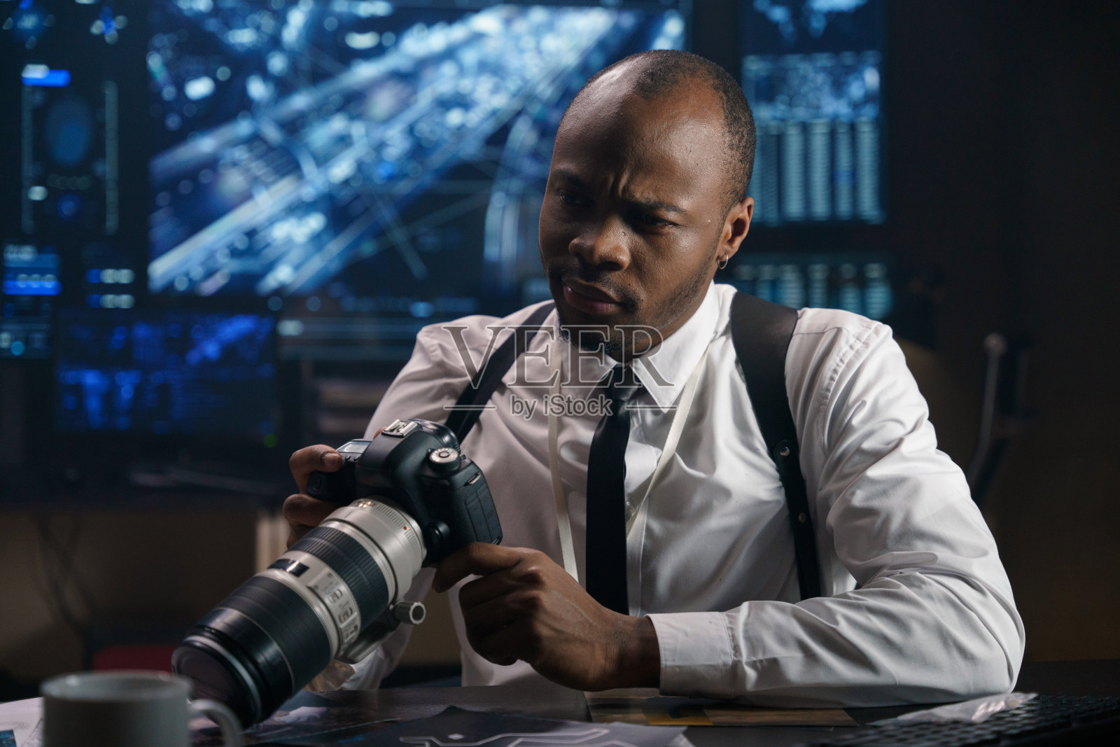 侦探在一个现代化的高科技警察局，他研究在一个秘密的特别行动中拍摄的照片。照片摄影图片