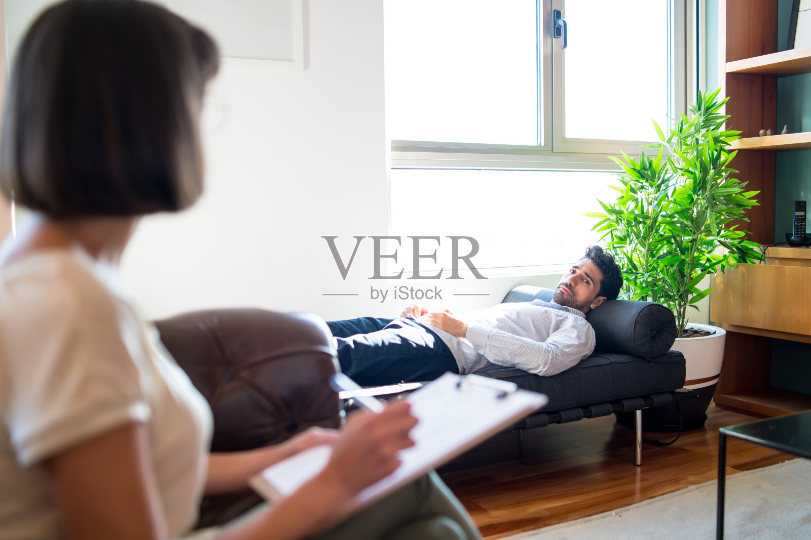 心理医生在治疗过程中与病人交谈。照片摄影图片