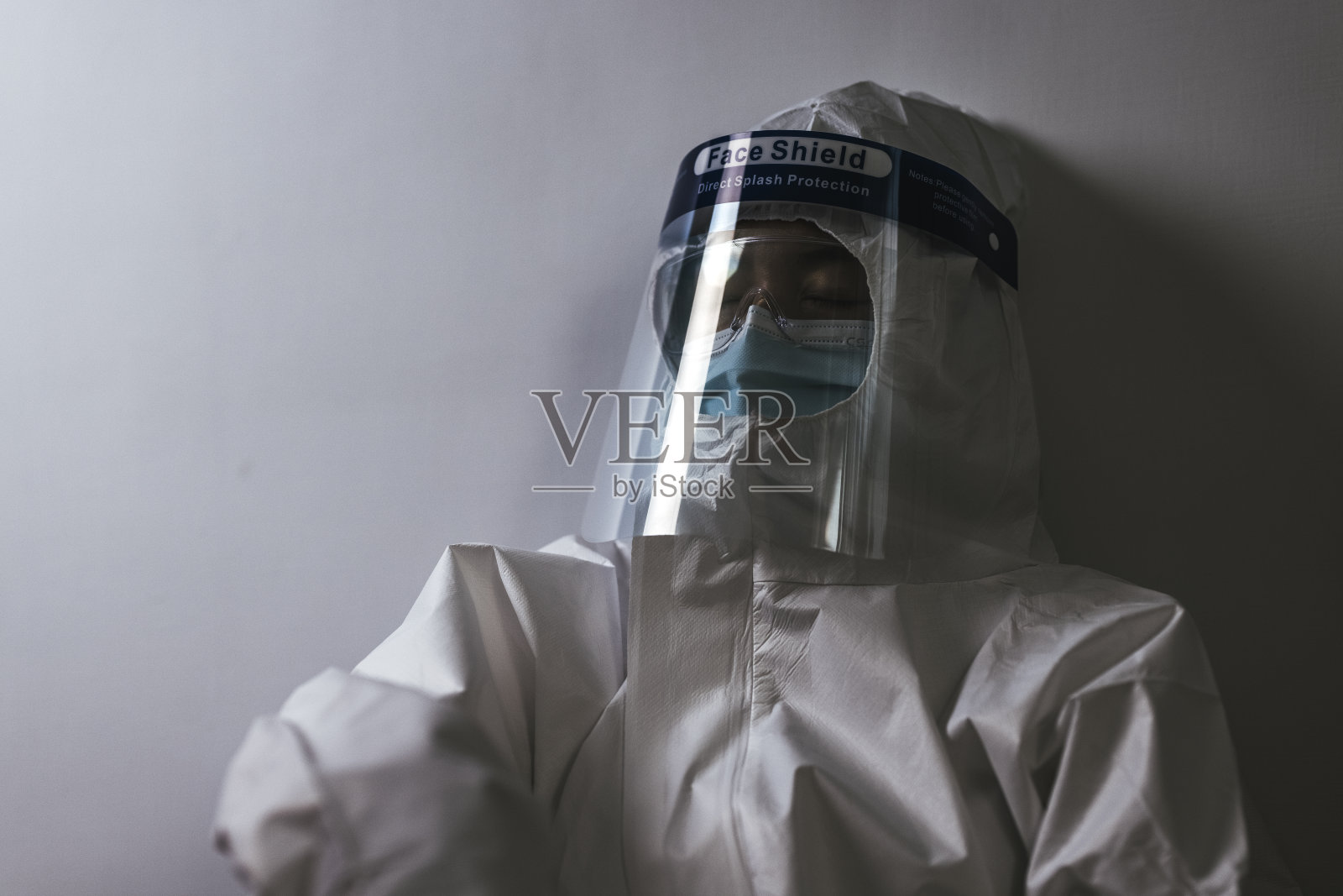 过度劳累、悲伤、疲惫的女医护人员坐在医院走廊的地板上照片摄影图片