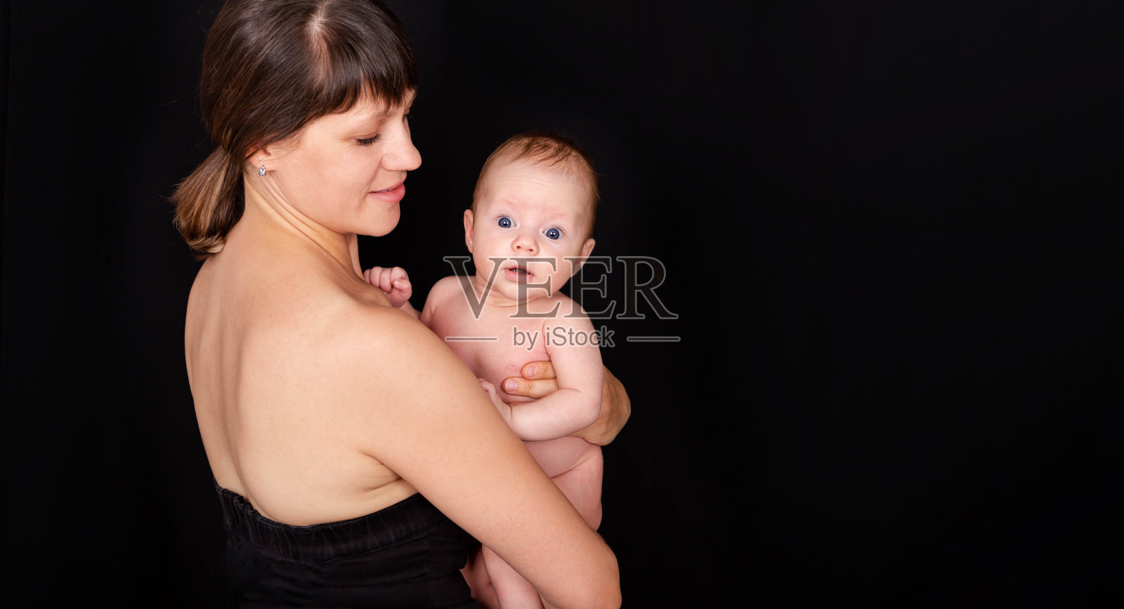 快乐的妈妈亲吻着宝贝男孩。照顾婴儿皮肤的母亲。照片摄影图片