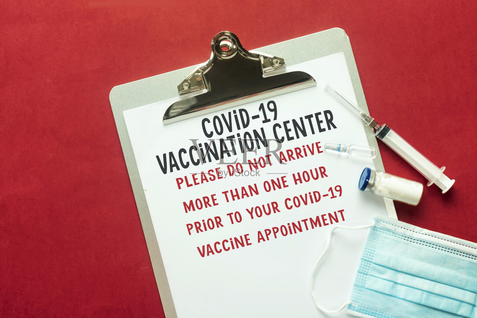 COVID-19疫苗接种中心笔记板上，医用口罩注射针照片摄影图片