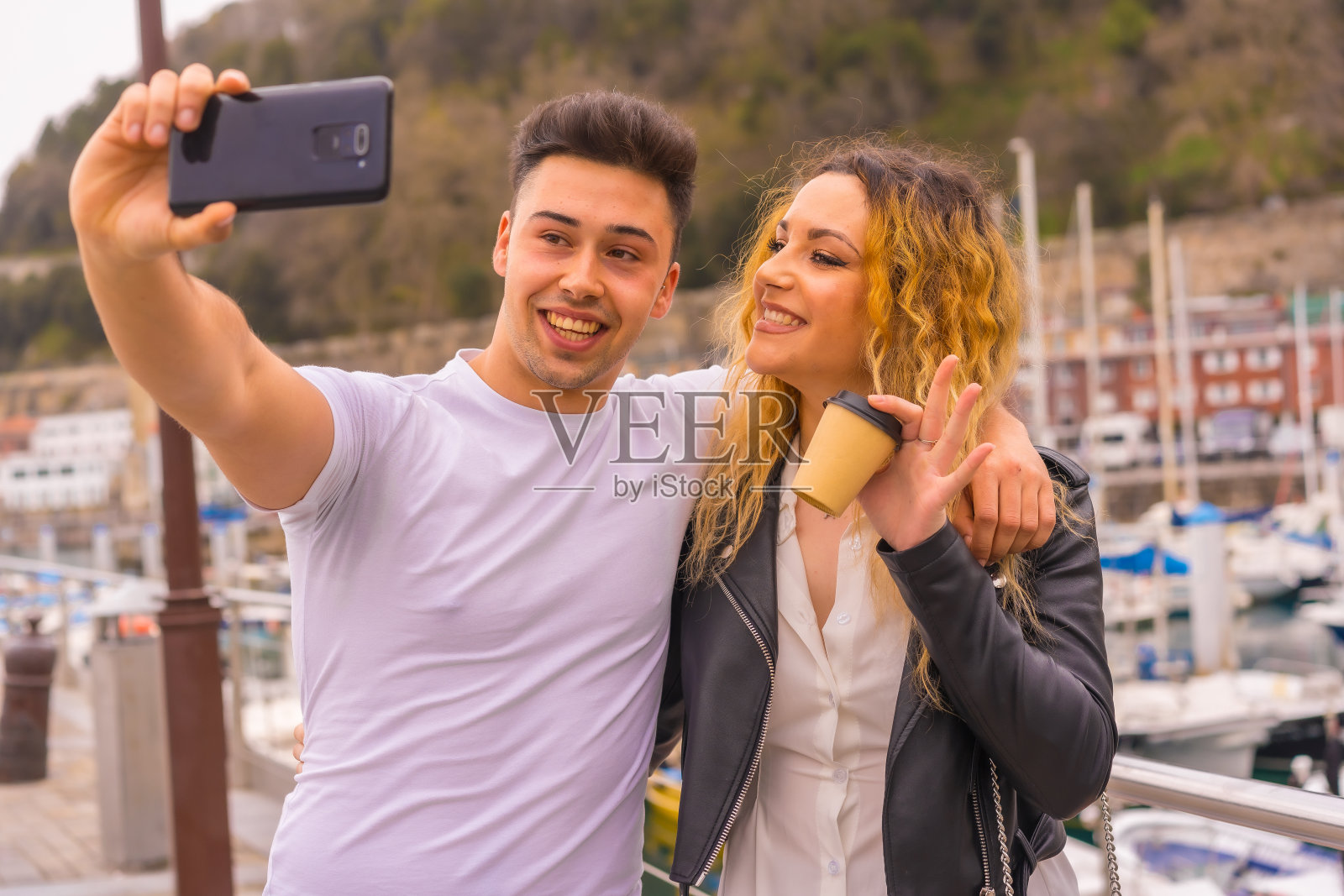 一对夫妇的生活方式观光和享受假期。在海港漫步并拍照照片摄影图片