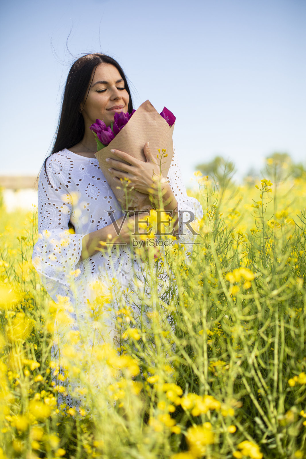 油菜地里的年轻女子照片摄影图片