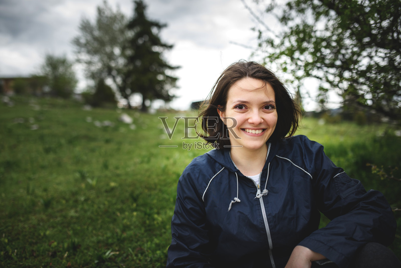 一个女人在徒步旅行后坐在大自然中休息的肖像。照片摄影图片