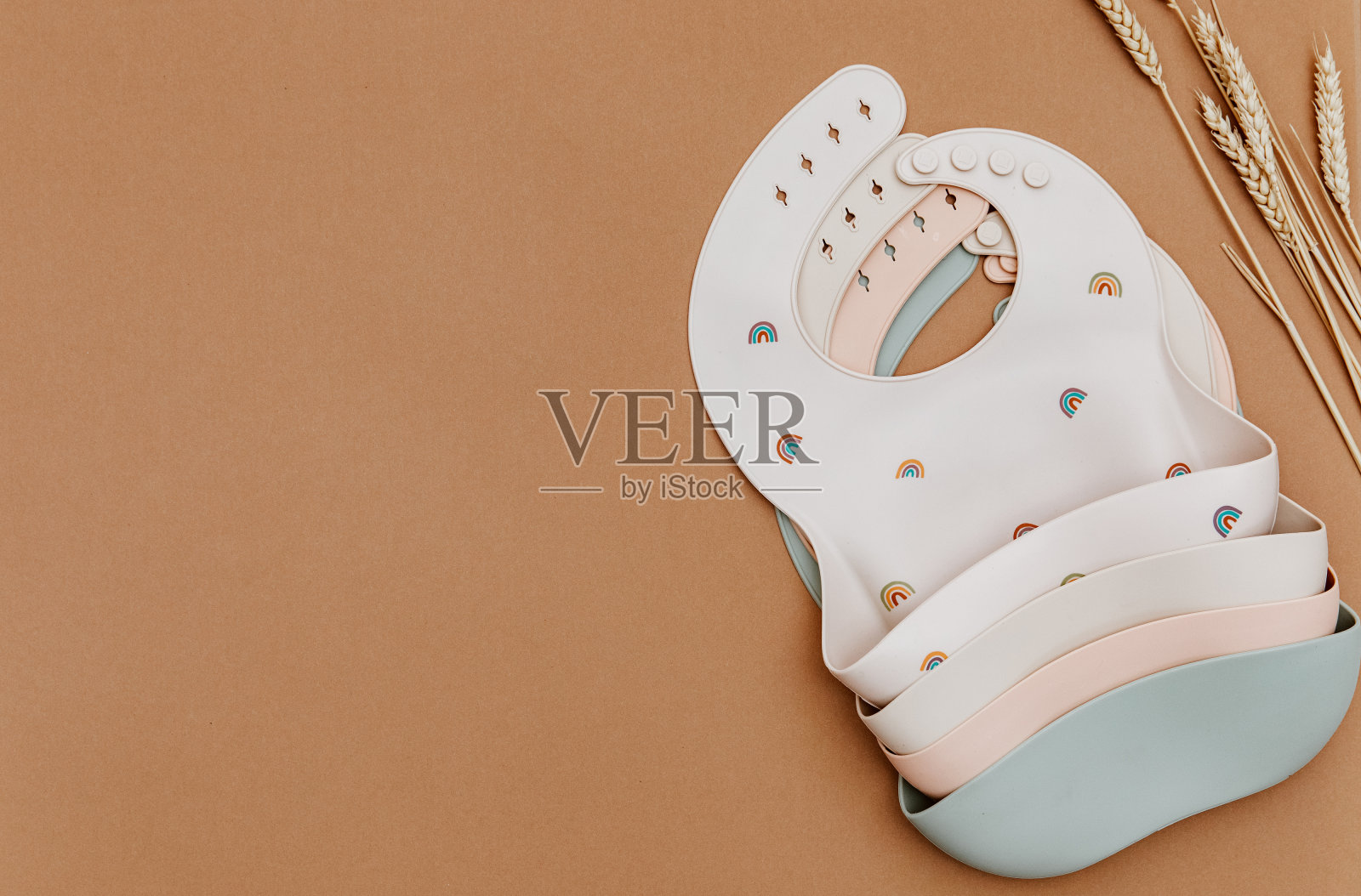 婴儿用硅胶围兜。第一个婴儿食品概念，为孩子提供食品照片摄影图片