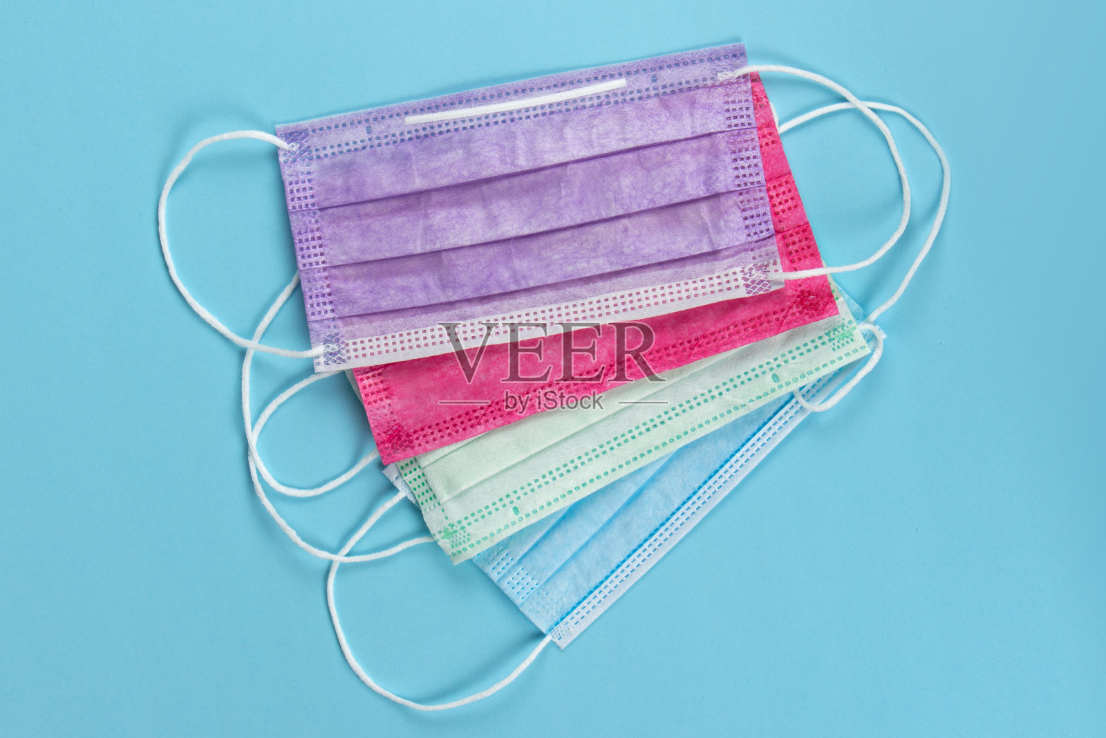 不同颜色的医用口罩，蓝色背景照片摄影图片