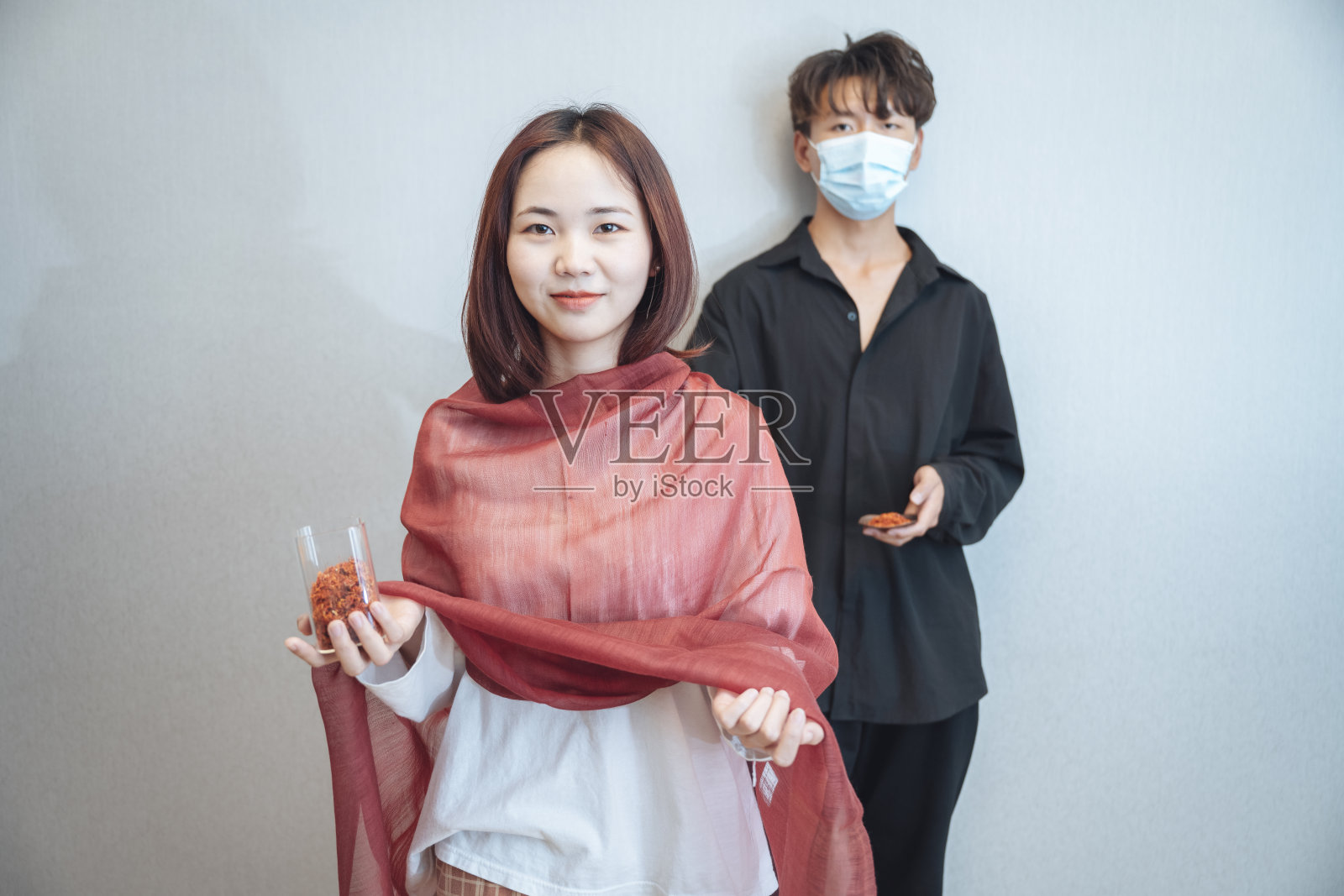 一个戴着红围巾的女孩和一个穿黑衬衫的男孩在干净舒适的环境中拖着天然植物染料照片摄影图片