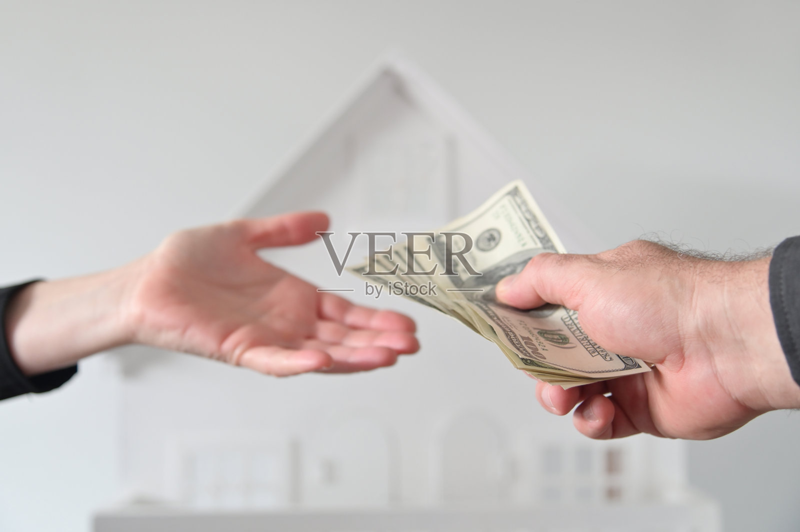 两个人在向一栋白房子砸钱照片摄影图片