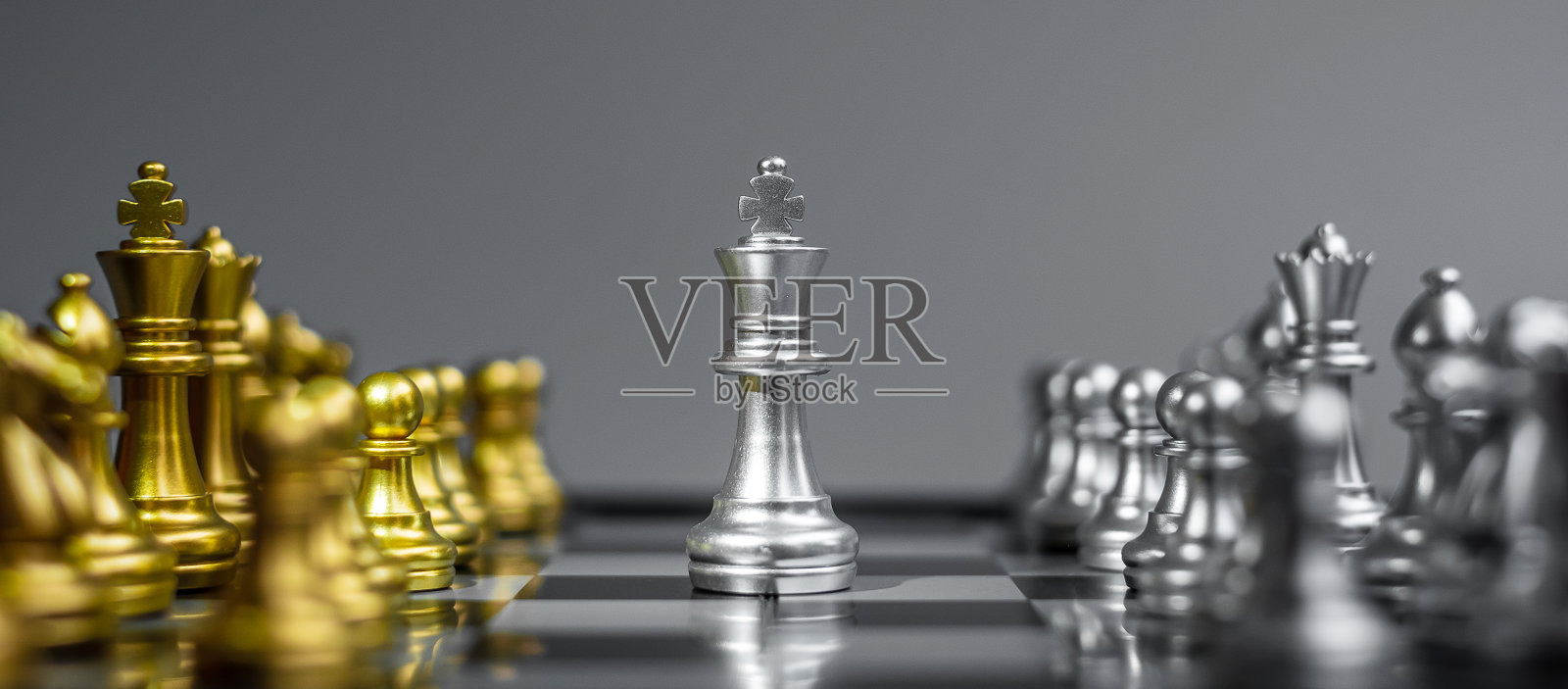 银和金的象棋人物在棋盘上对抗对手在战斗中。战略，成功，管理，商业计划，思考，教育和领导者的概念照片摄影图片