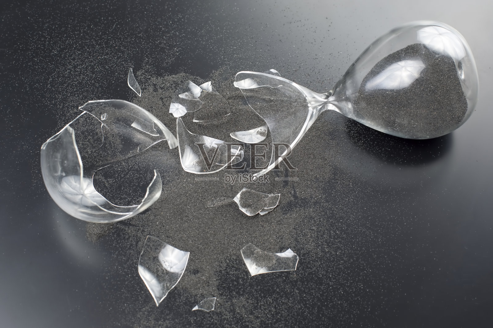 破碎的沙漏。浪费时间。结束的机会。停止测量时间。玻璃碎片。破碎的希望。照片摄影图片