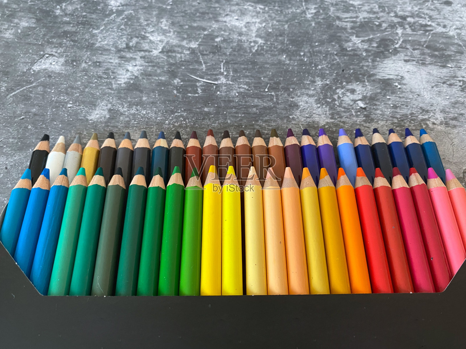 灰色书桌上的一套彩色铅笔照片摄影图片
